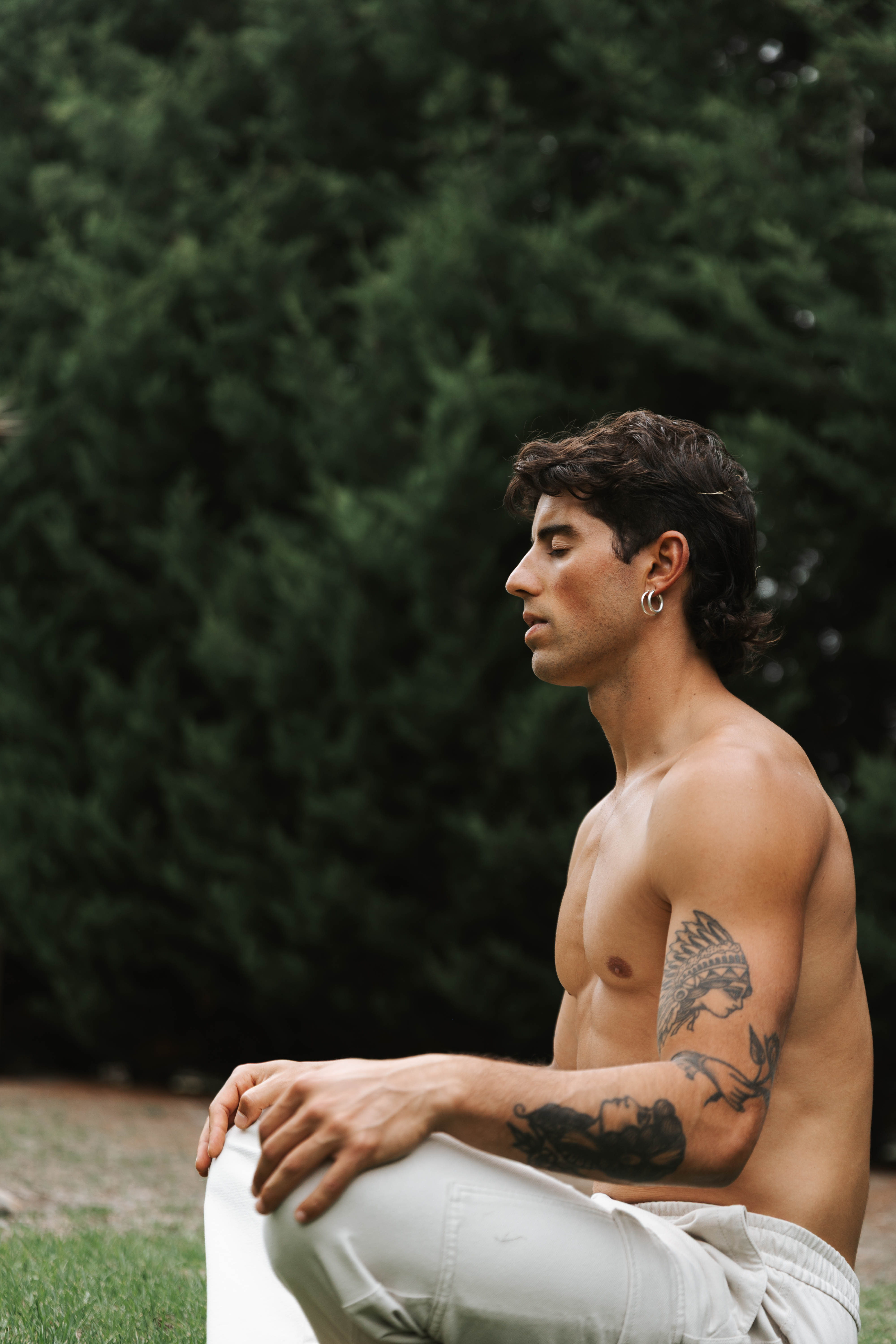 Tristan sitting in stillness among trees, eyes closed
